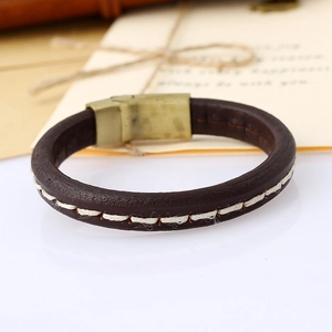 Close-up of vintage brown leather bracelet with white stitching and brass magnetic clasp