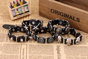 Detail of four punk leather bracelets with star, spike, disc, and skull metal charms
