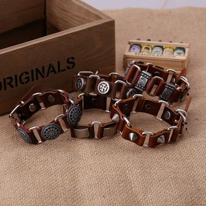 Bracelet punk en cuir marron avec breloques en métal argenté sur toile de jute rustique