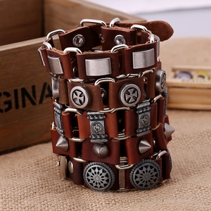Ensemble de bracelets en cuir marron avec breloques vintage sur fond en bois