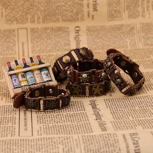 Détail de bracelets punk en cuir vintage avec breloques tête de mort et croix