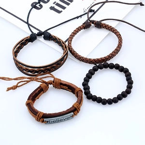 Détail d'un ensemble de 4 bracelets en cuir avec breloque en métal gravée 'believe' dessus