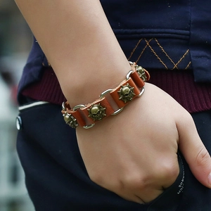 Vintage punk leather bracelet with bronze skull charms for men shown on a wrist