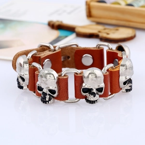 Détail du bracelet en cuir punk avec breloques crânes argentés et fermoir à bouton-pression
