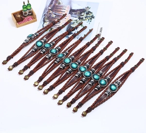 Detail of vintage layered leather zodiac bracelets with beaded charms and bronze snaps