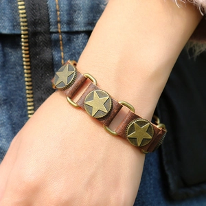 Détail du bracelet punk en cuir vintage avec rivets d'étoiles en bronze et maillons