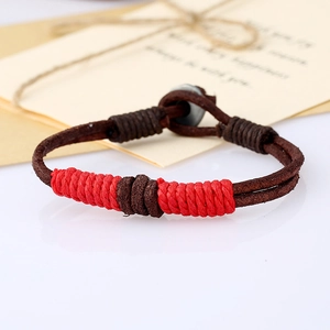 Detail of handcrafted woven leather bracelet with vintage metal button and thread decor