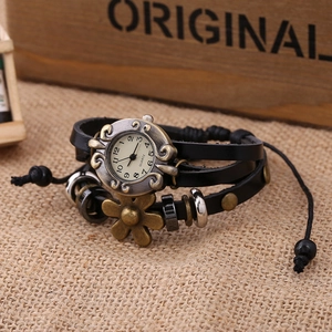Detail of vintage leather wrap watch with flower charm and beads on burlap background