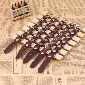 Five vintage leather bracelets with punk skull charms displayed on newspaper background