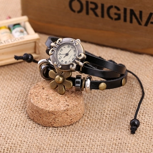 Close-up of vintage multilayer black leather strap watch with bronze flower beads