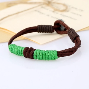 Macro shot of vintage hand-woven brown leather bracelet with green thread details