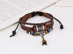Detail of vintage multilayer leather bracelet with a bronze Eiffel Tower charm and beads