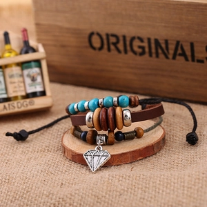 Detail of multilayer leather bracelet with turquoise beads and diamond-shaped pendant