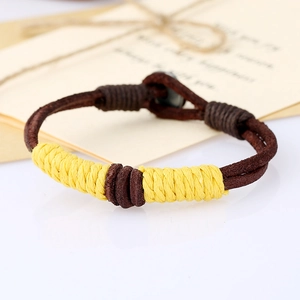 Close-up of a braided brown leather bracelet with yellow cord on a gift envelope