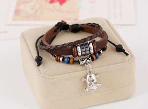 Detail of multi-layer leather bracelet with wooden beads and silver skull charm