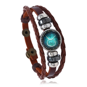 Detailed macro view of Taurus zodiac sign cabochon on a multi-layer leather bracelet