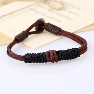 Close-up of vintage braided leather bracelet with metal clasp and gift card background