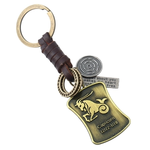 Détail macro du porte-clés Capricorne en cuir vintage avec emblème en bronze antique