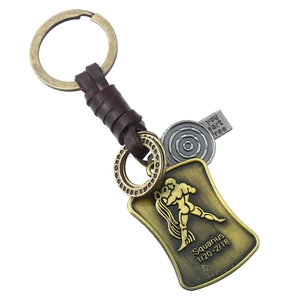 Détail du porte-clés Verseau vintage avec lanière en cuir tressé et gravure en bronze