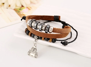 Detail eines mehrlagigen Lederarmbands mit silbernem Buddha-Anhänger und Perlen