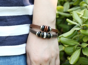 Close-up of multilayer leather bracelet with wooden beads and silver rhinestone accent