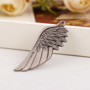 Detail showing vintage silver alloy wing pendant with intricate carved feather textures