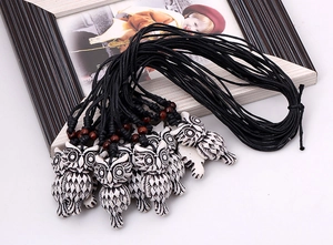 Detail of owl resin pendant necklaces with wooden beads and black wax cord straps