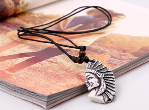 Détail du pendentif chef indien en résine vintage avec cordon noir et perles bois