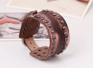 Gros plan détaillé du bracelet large en cuir punk vintage avec clous et boucle en métal