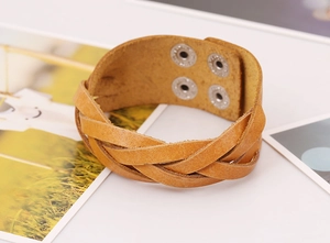 Detail of woven ginger leather bracelet featuring four adjustable metal snap buttons