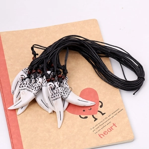 Collier tribal avec pendentif en forme de dent de loup, cordon noir et perles en bois