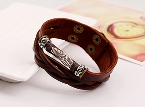 Detailed shot of retro multilayer brown leather bracelet featuring a silver metal feather charm