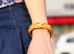 Detail of hand-woven ginger leather bracelet on wrist with vintage braided design