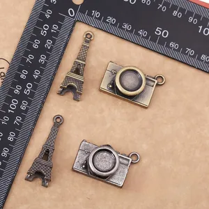 Retro bronze Eiffel Tower and camera pendants with ruler showing 3.5cm and 2cm size details