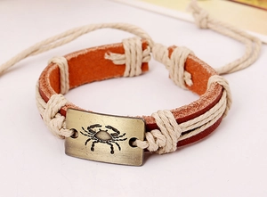 Close-up of vintage leather Cancer zodiac bracelet with antique bronze metal crab charm