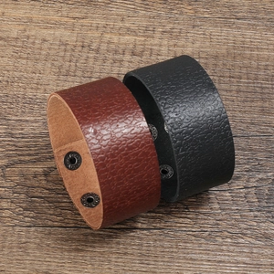 Gros plan de bracelets en cuir rétro noir et marron avec boutons-pression en métal