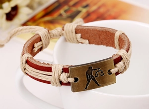 Detail of Libra zodiac leather bracelet with bronze metal plate and woven rope textures