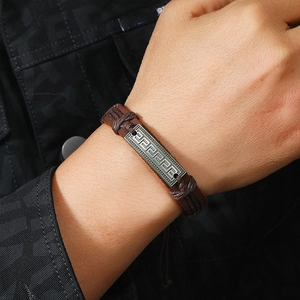Handmade woven leather bracelet for men featuring a vintage Greek key pattern metal charm