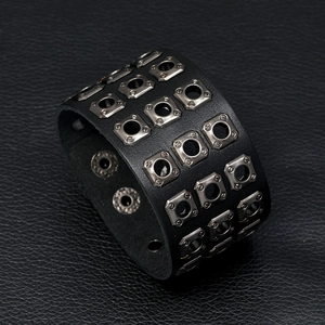 Detail of a vintage punk leather bracelet featuring three rows of square metal studs