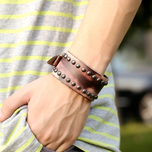 Bracelet large en cuir rétro punk avec rivets en bronze porté en milieu naturel extérieur