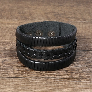 Gros plan sur un bracelet en cuir tressé multicouche noir avec bouton-pression en métal