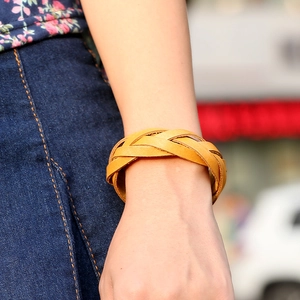 Handwoven light brown leather bracelet shown on wrist against a casual background