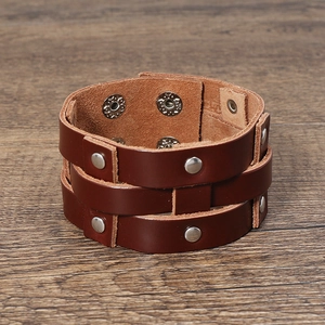 Detail of wide brown leather punk bracelet with silver metal studs and snap closures