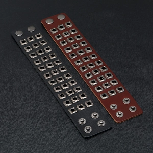 Detail of vintage punk leather bracelet with triple row square metal rivets and snap buttons
