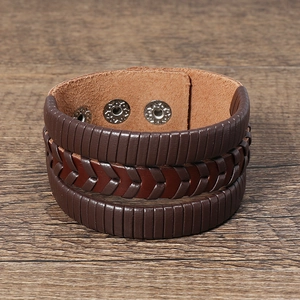 Détail du bracelet en cuir vintage avec couches tressées et boutons en métal réglables