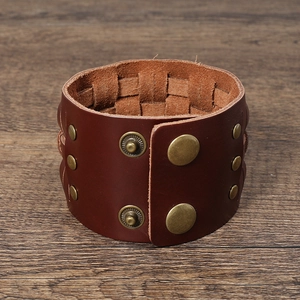 Macro detail of dark brown woven leather bracelet with vintage bronze snap fasteners
