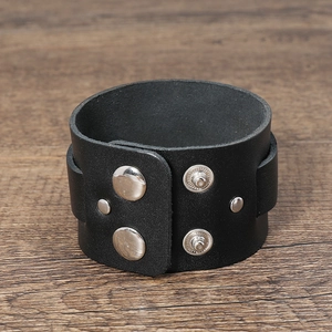 Detail of black wide leather bracelet with silver adjustable metal snap fasteners