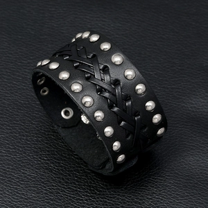 Detail of punk leather bracelet with silver studs and intricate braided leather pattern
