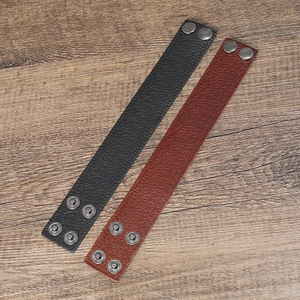 Vue détaillée de bracelets en cuir noir et marron vintage avec boutons-pression en métal