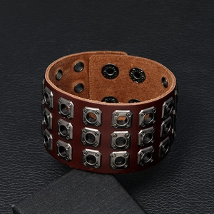 Detail of dark brown leather punk bracelet featuring triple row rectangular metal eyelets